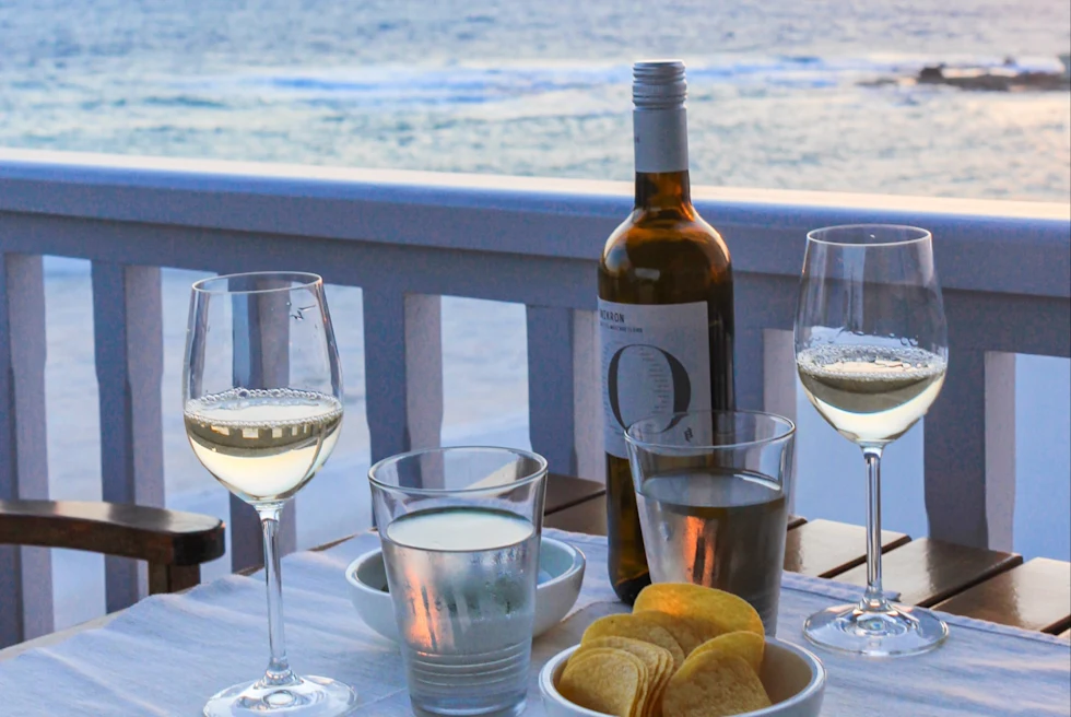 white table with two glasses of wine overlooking a body of water