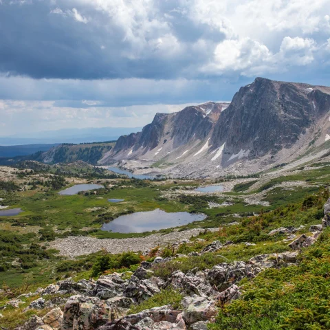 A valley with mountains and a cloudy sky. 