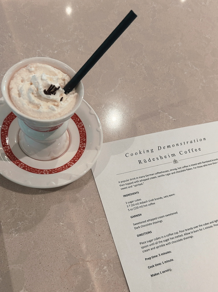 A cup of coffee on a table next to a menu 