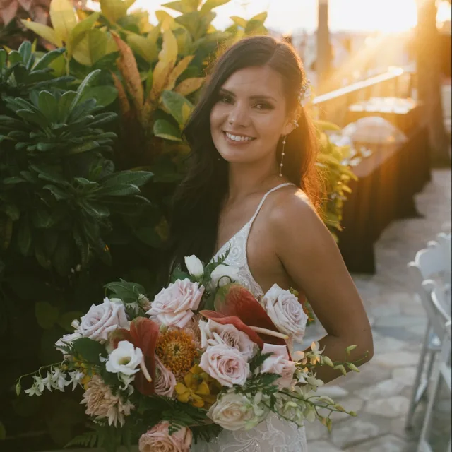 Travel Advisor Alyssa Lee in a white wedding dress with pink flowers.