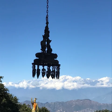 An aerial view of a statue near mountains during daytime.