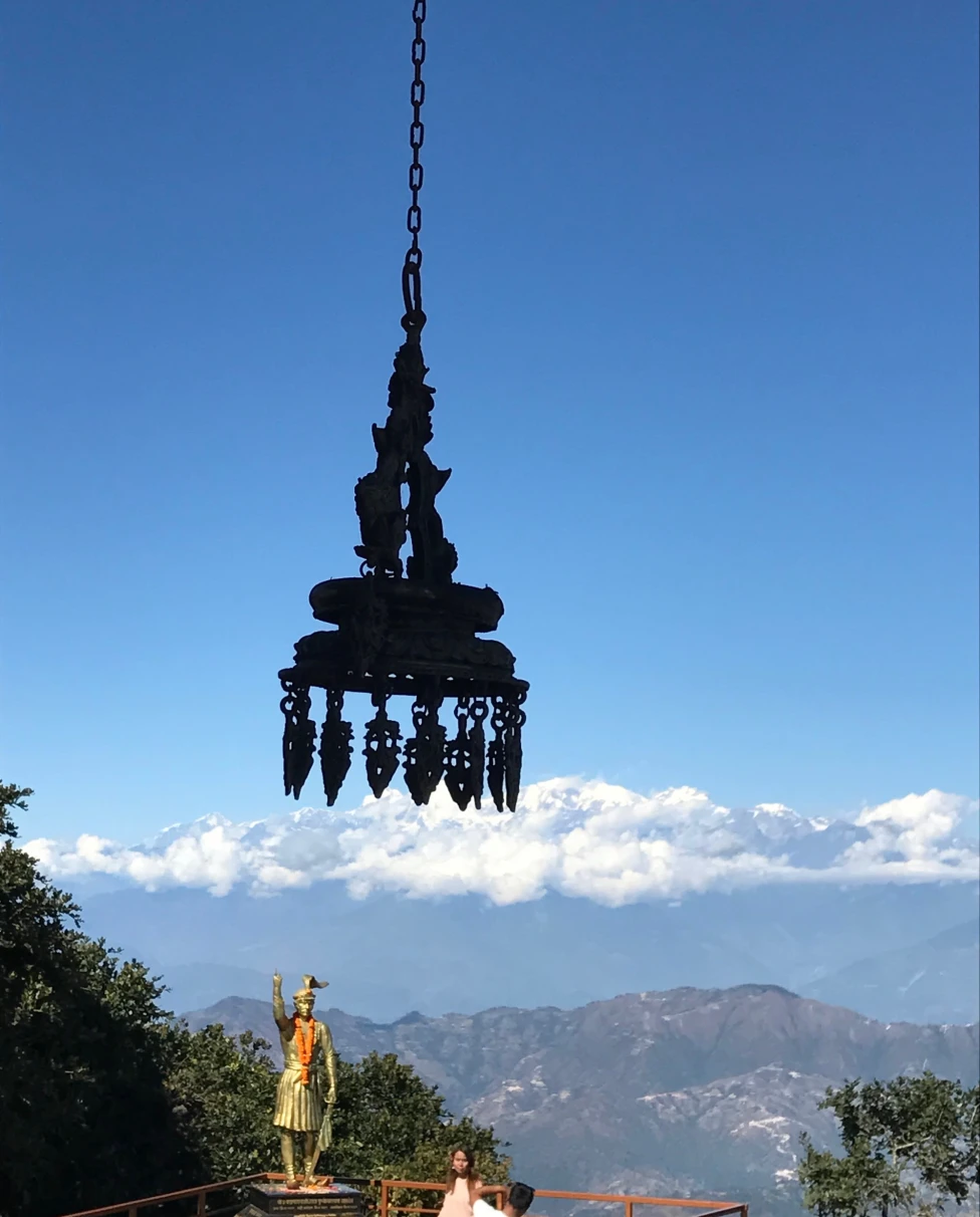 An aerial view of a statue near mountains during daytime.