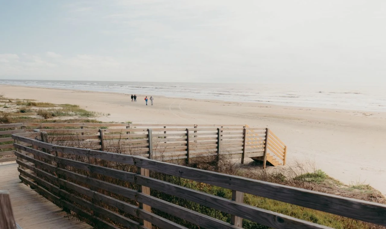A wooden boardwalk sitting on a beach during daytime