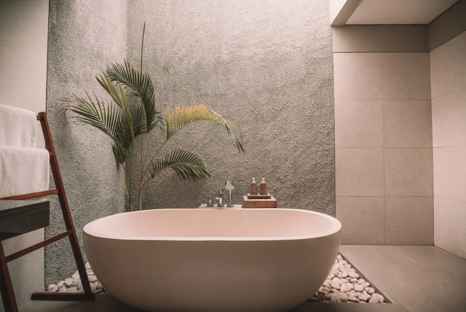 a ceramic outdoor bathtub near palm leaves