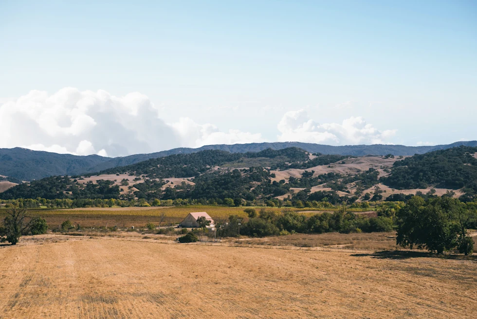 farm land with mountains in the background during daytime