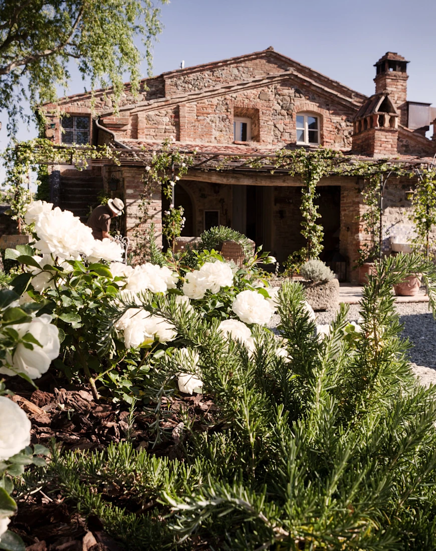a stone farmhouse covered with greenery
