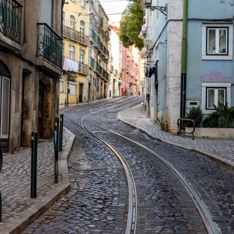A cobblestone street with a train track running through it.