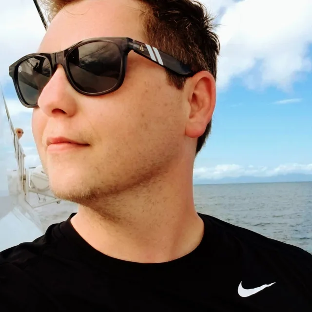 Travel Advisor Jeremy Barber posing on a ship in sea with sunglasses. 