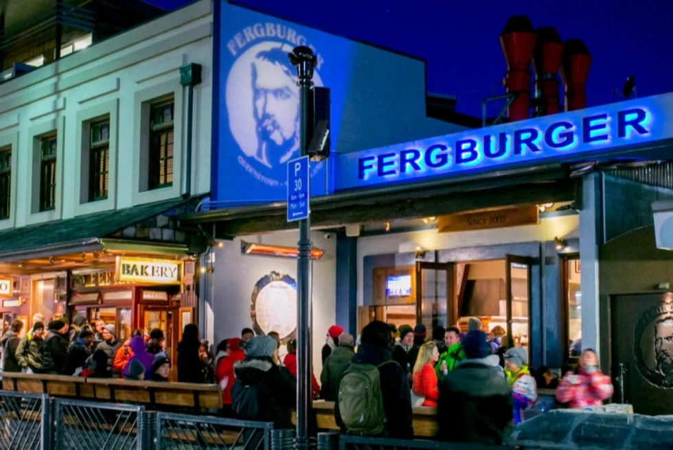 People sitting outside restaurant named Fergburger.