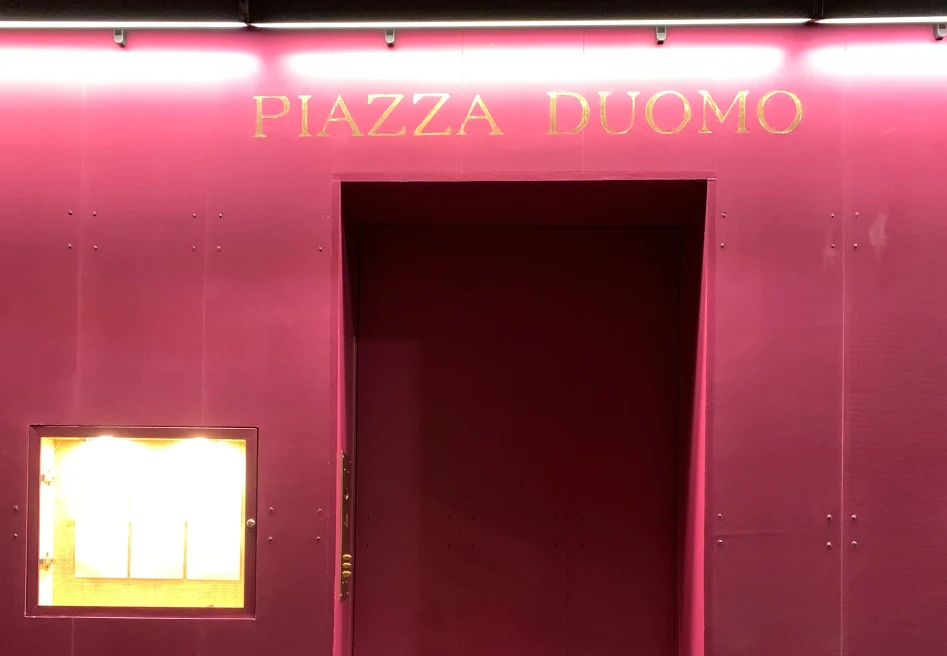 red door with gold lettering that reads, Piazza Duomo