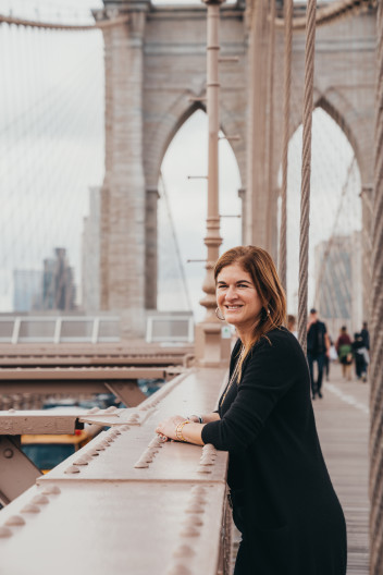 Deb Swacker, a Fora Advisor, smiles from the Brooklyn Bridge in New York City