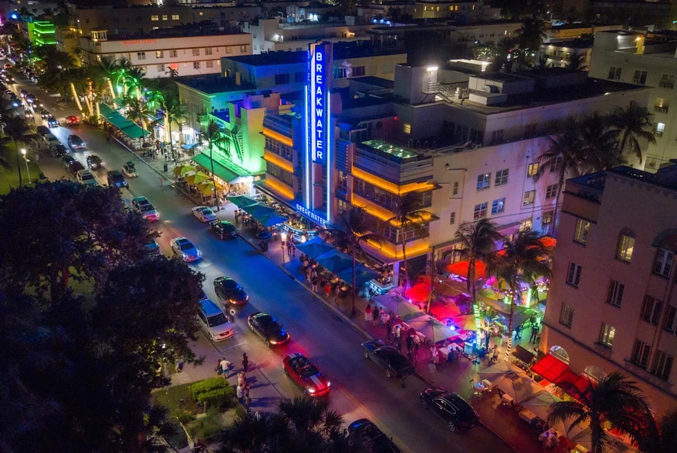 street in a beach town with multicolored lights emanating from neon signs at night