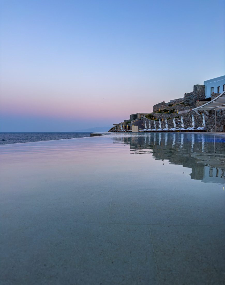 a resort overlooking a long infinity pool at night