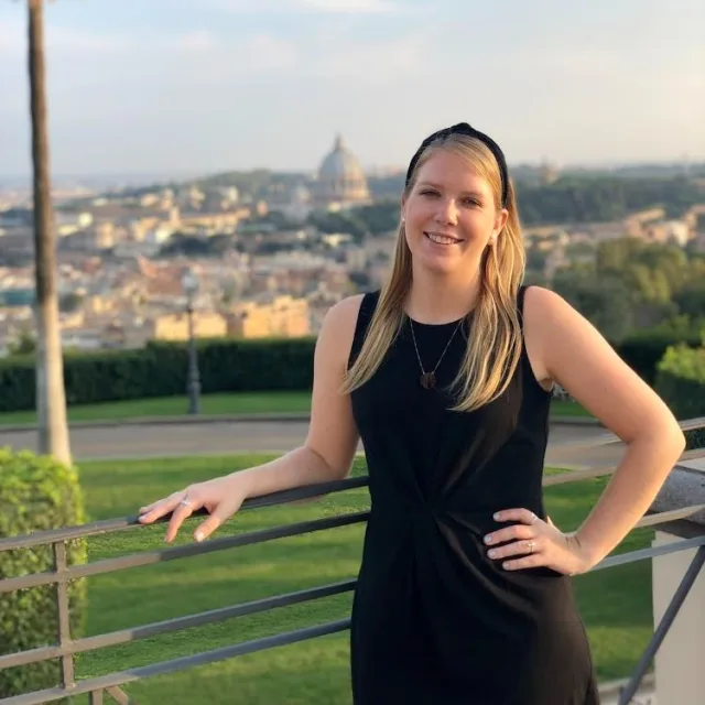 Travel advisor wears a black dress on a balcony over looking a city