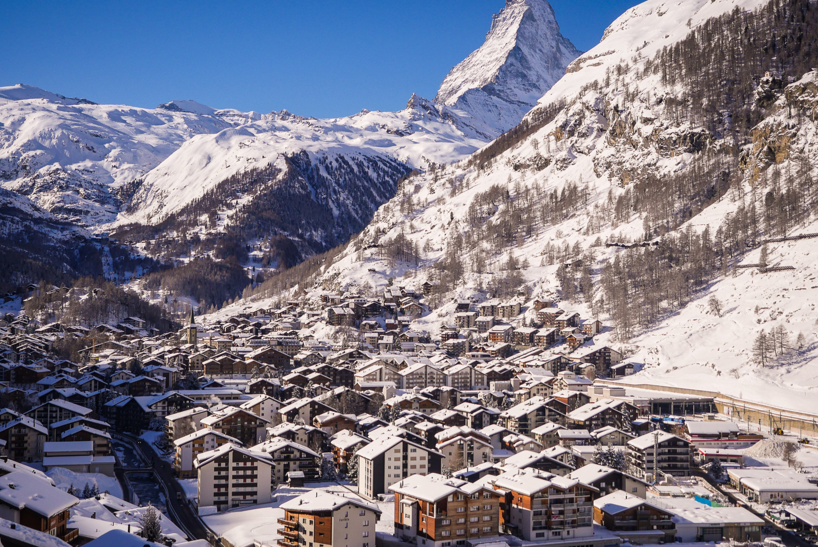 village with snowy mountains in the background