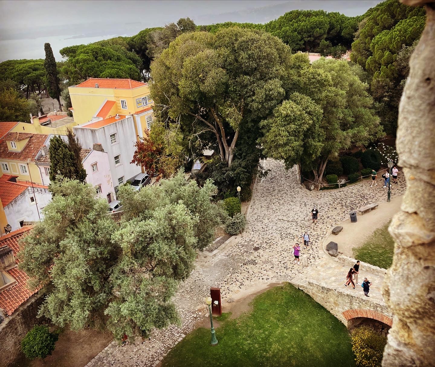 view from castle onto colorful rooftops and ocean below on a overcast day