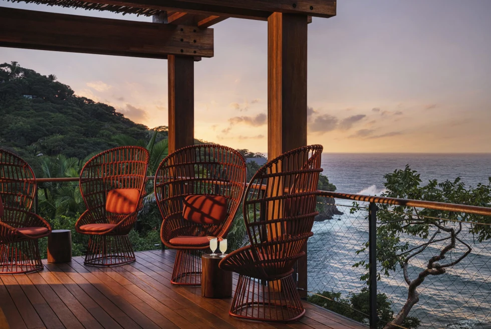 tables and chairs overlooking the ocean during sunset