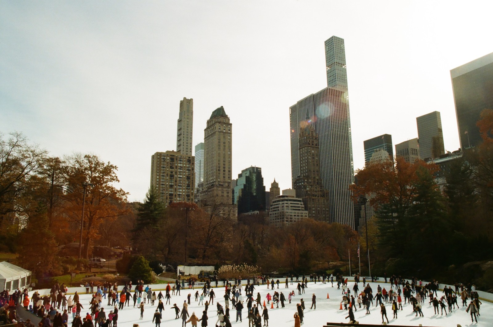 people on ice skating rink surrounded by buildings