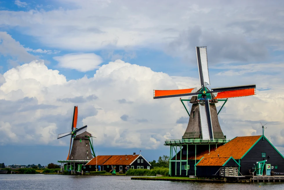 Large windmills next to body of water during daytime