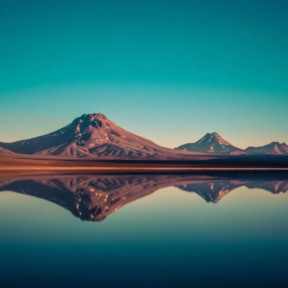 Mountains reflecting in the water under a blue sky in Chile