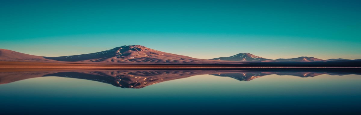 Mountains reflecting in the water under a blue sky in Chile