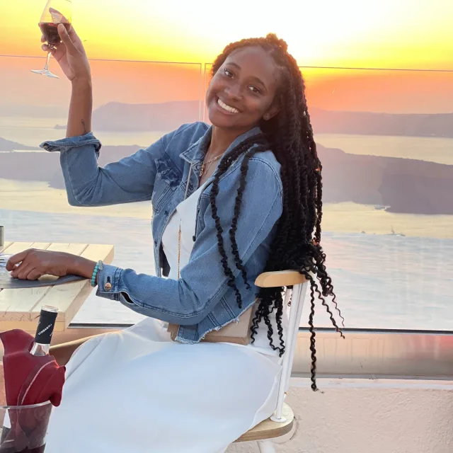 Travel advisor Brittany Archer in a white dress and jean jacket on a balcony