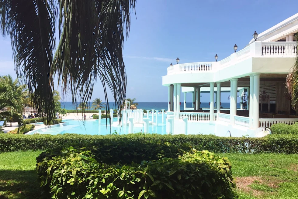 pool outside a white house on the ocean