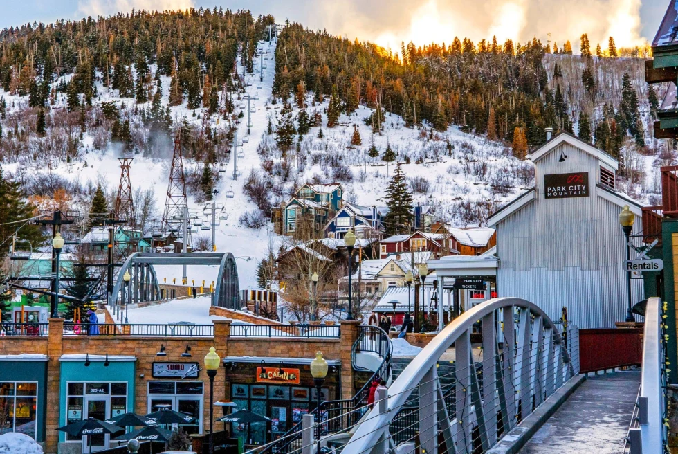 a downtown with a bridge at the base of a ski mountain 