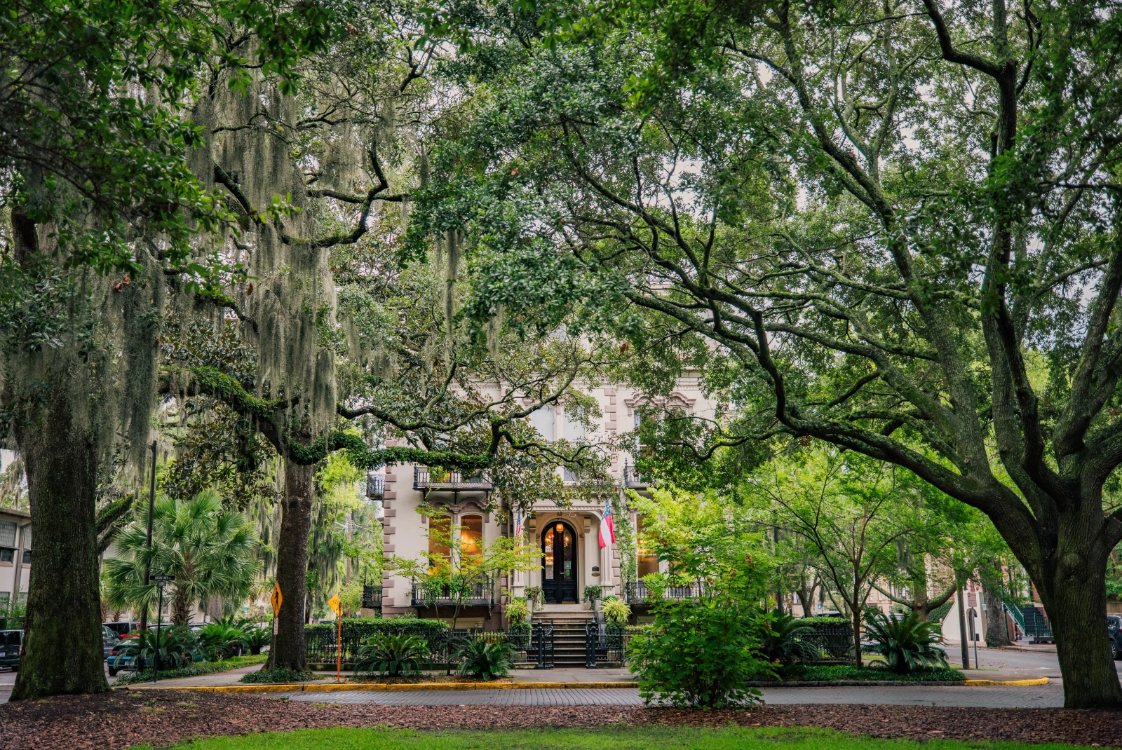 A colonial-style home surrounded by lush vegetation in Savannah, Georgia. 