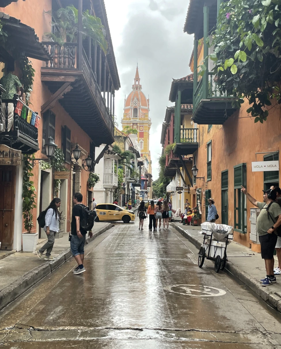 Streets of Cartagena with colorful buildings and pedestrians. 