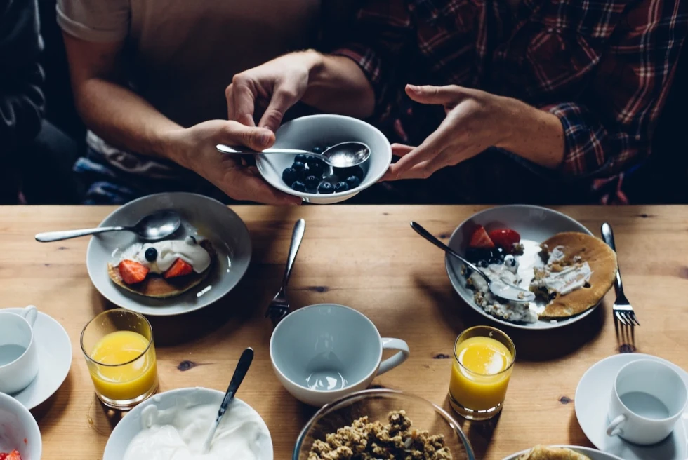 aerial view of a wooden table with bowls of yogurt and berries