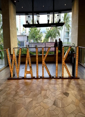A picture of the Waikiki sign taken at some restaurant during the daytime.