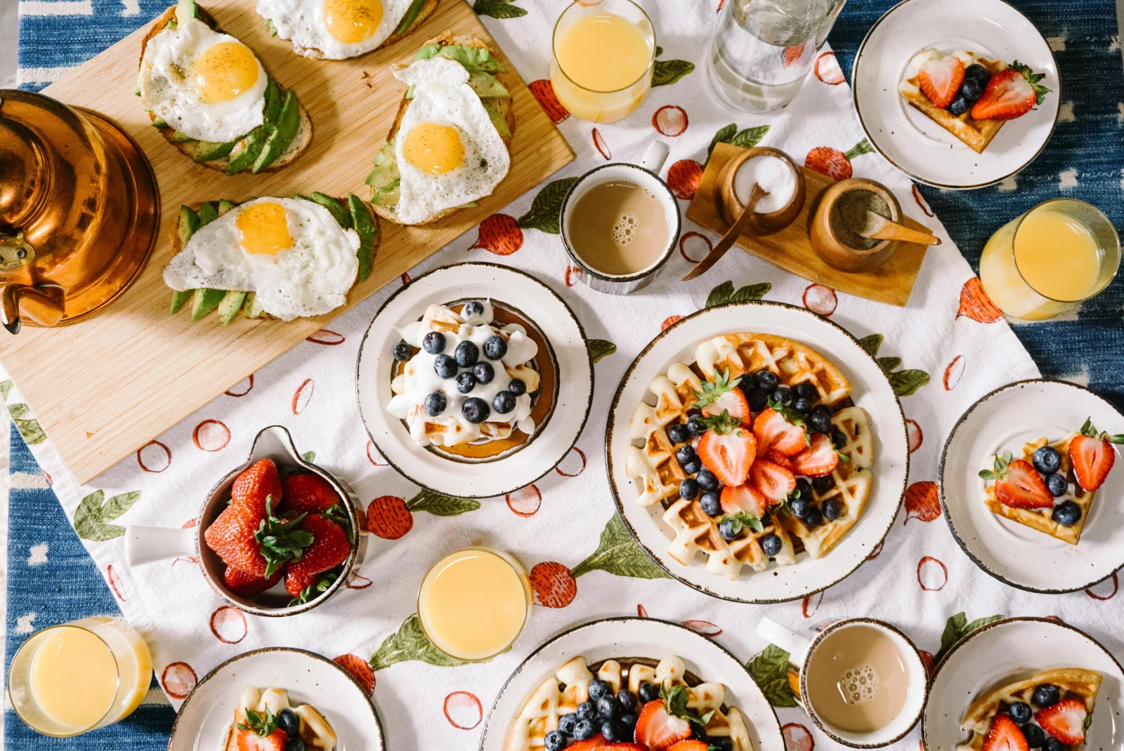 A brunch spread featuring waffles, eggs, avocado toast and more. 
