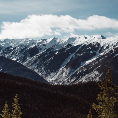 snowy mountains with cloudy skies during daytime