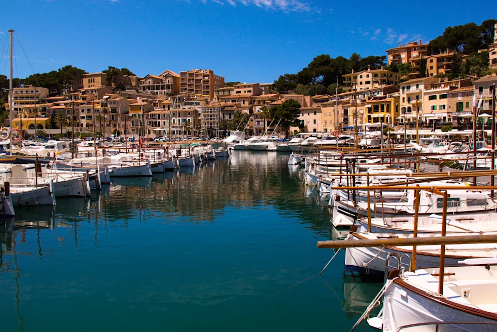 Boats parked on a water body surrounded by buildings.