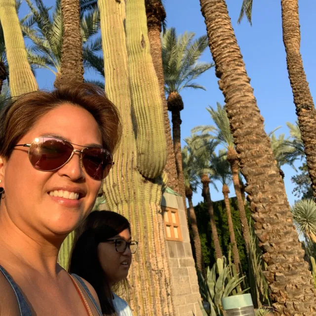 Travel Advisor Aimee Adamos with green cacti and palm trees in the background.