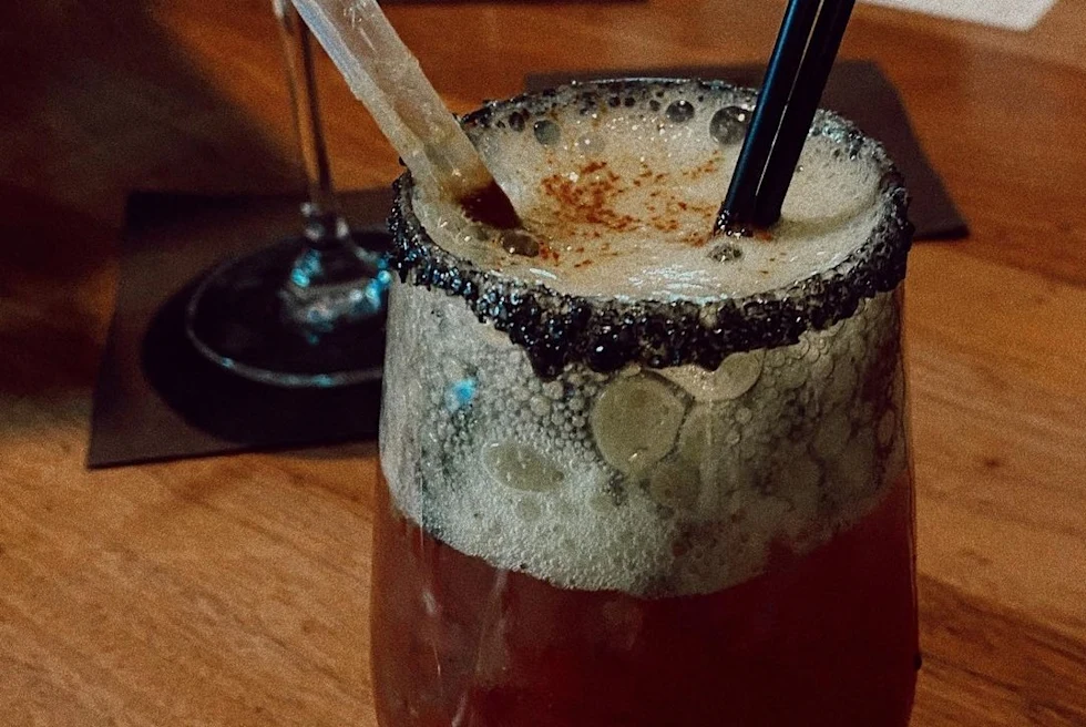 A glass with brown drink.