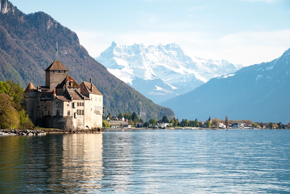 building next to a lake with mountains in the background