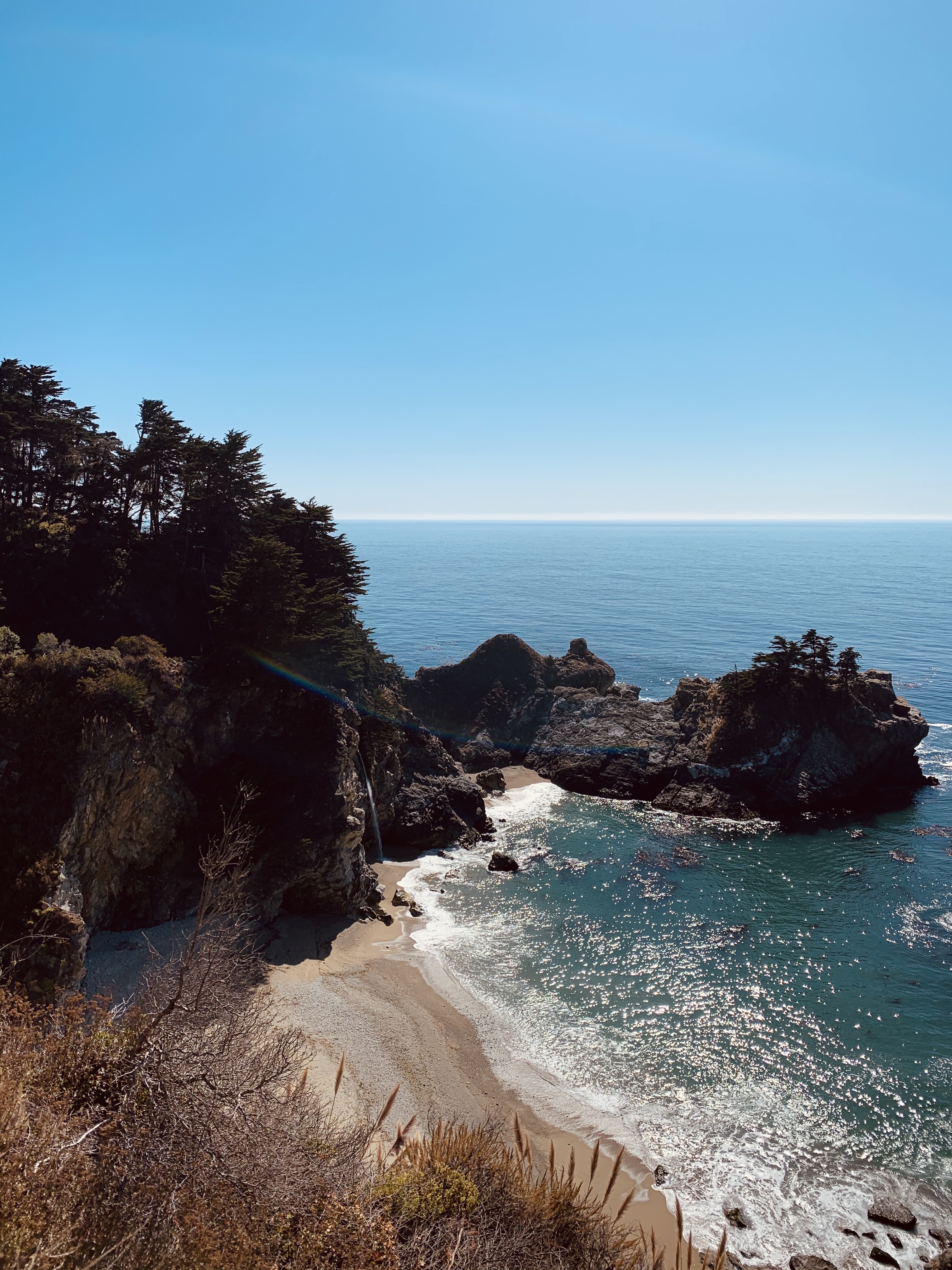 rocky coastline next to body of water during daytime