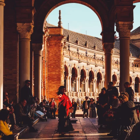 people dancing under a large archway during daytime