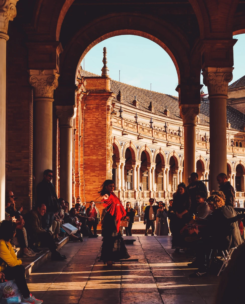 people dancing under a large archway during daytime