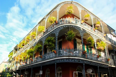 The Whitney Hotel building in New Orleans – a three-story building with ornate balconies and hanging plants