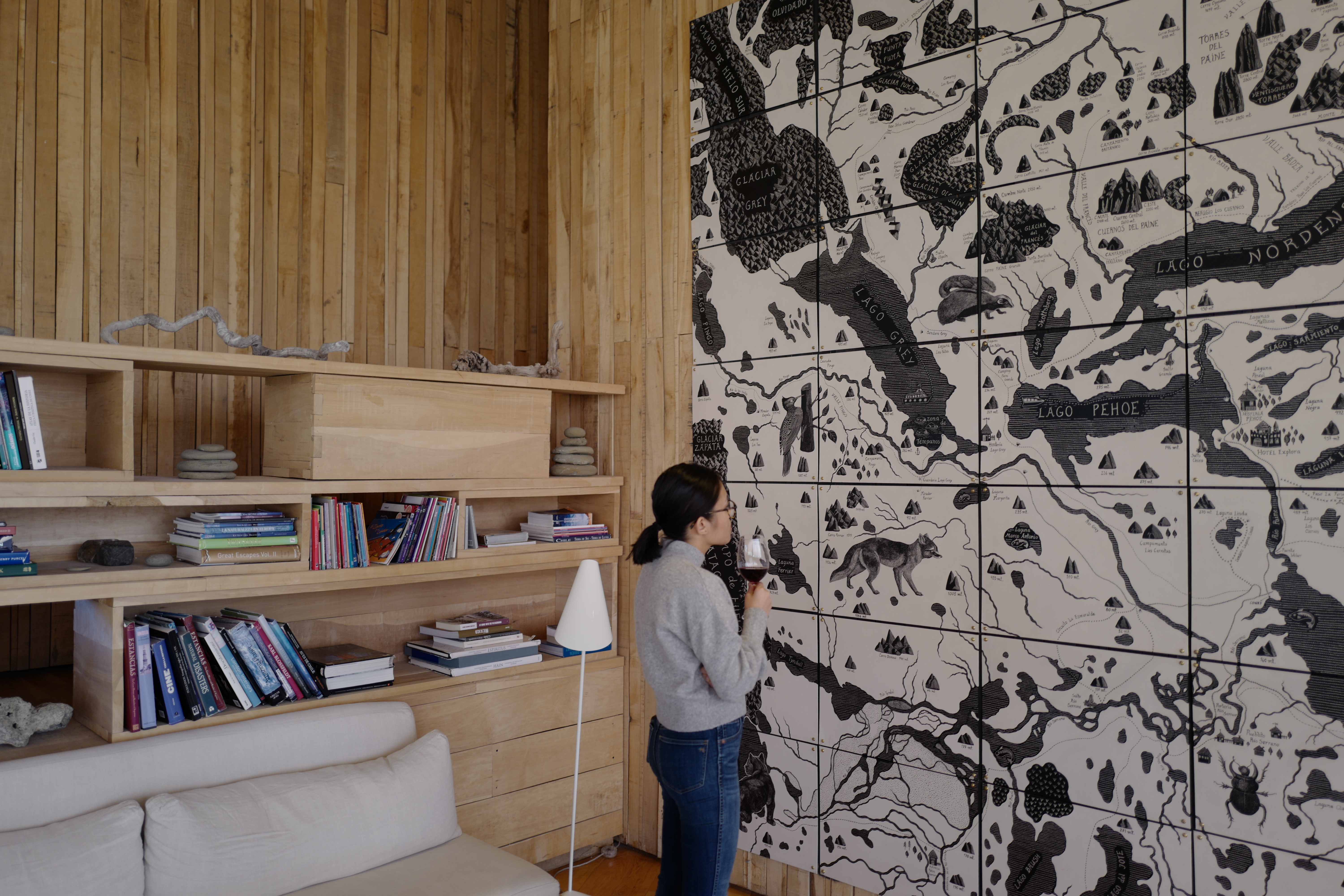 Girl looking at art and drinking wine.