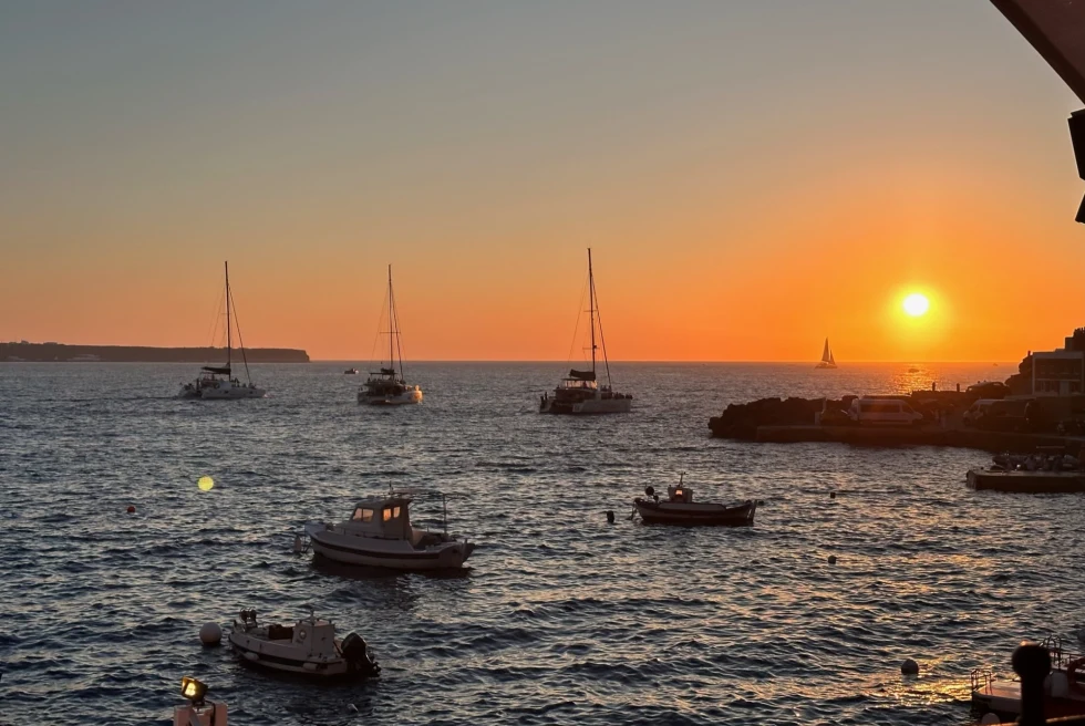 Sunset on an ocean with boats. 