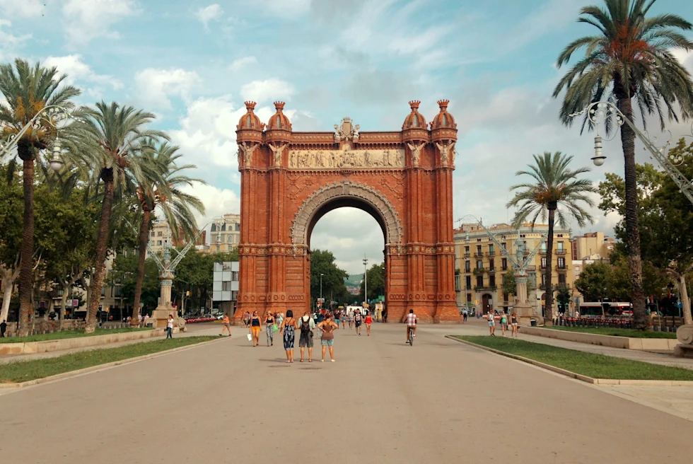 large arch over street next to palm trees during daytime