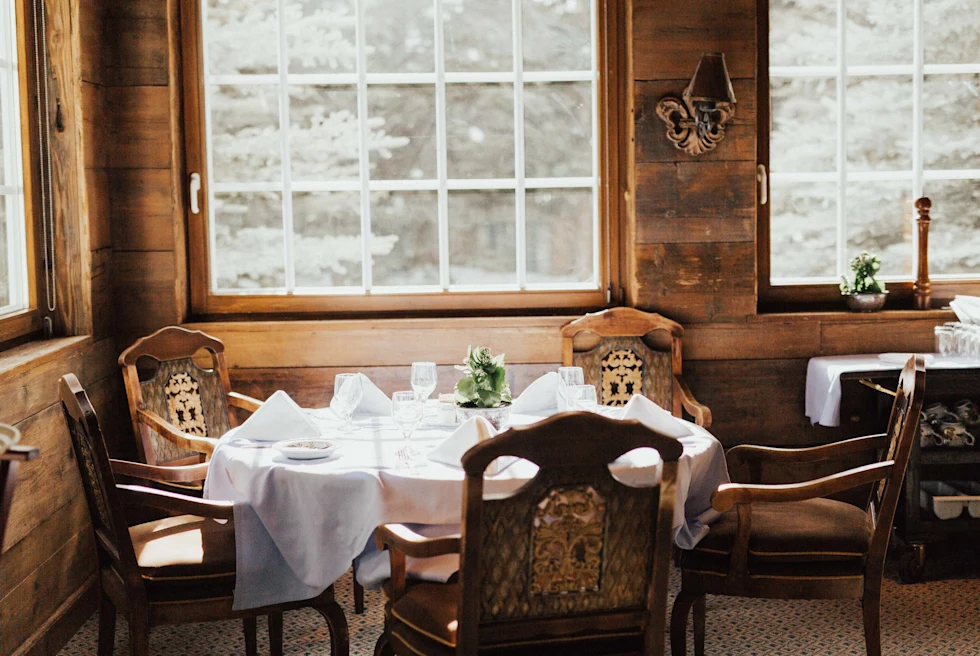 table with wooden chairs in a room with wood walls