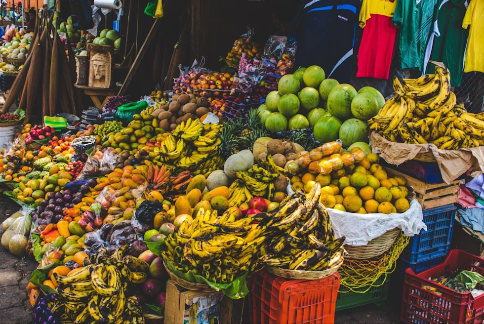 overflowing table of colorful fruits and vegetables at an outdoor market stand