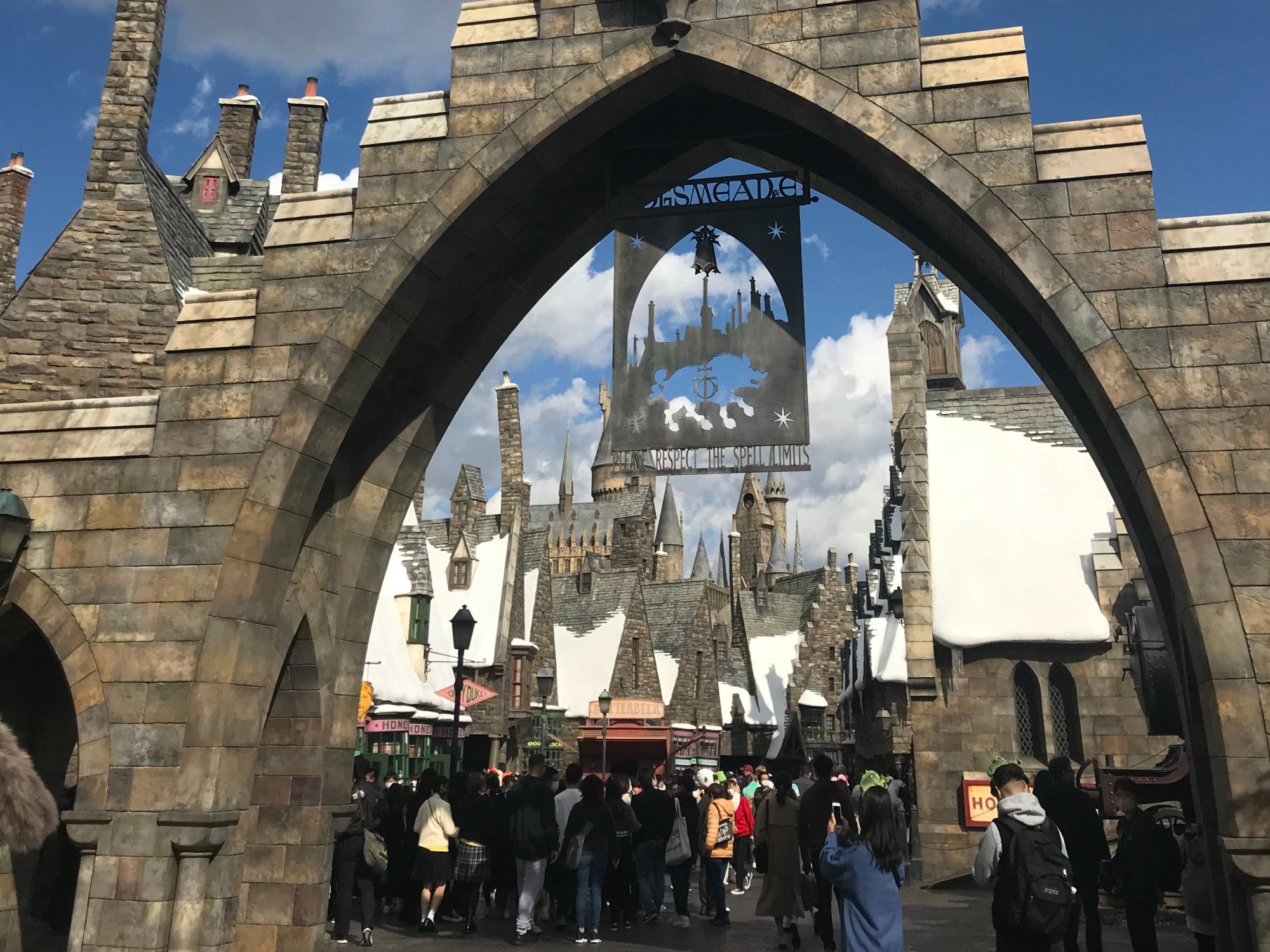 Entrance to Hogsmeade town in universal studio with people inside.