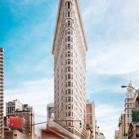 Flatiron building and a yellow taxi cab in NYC. 