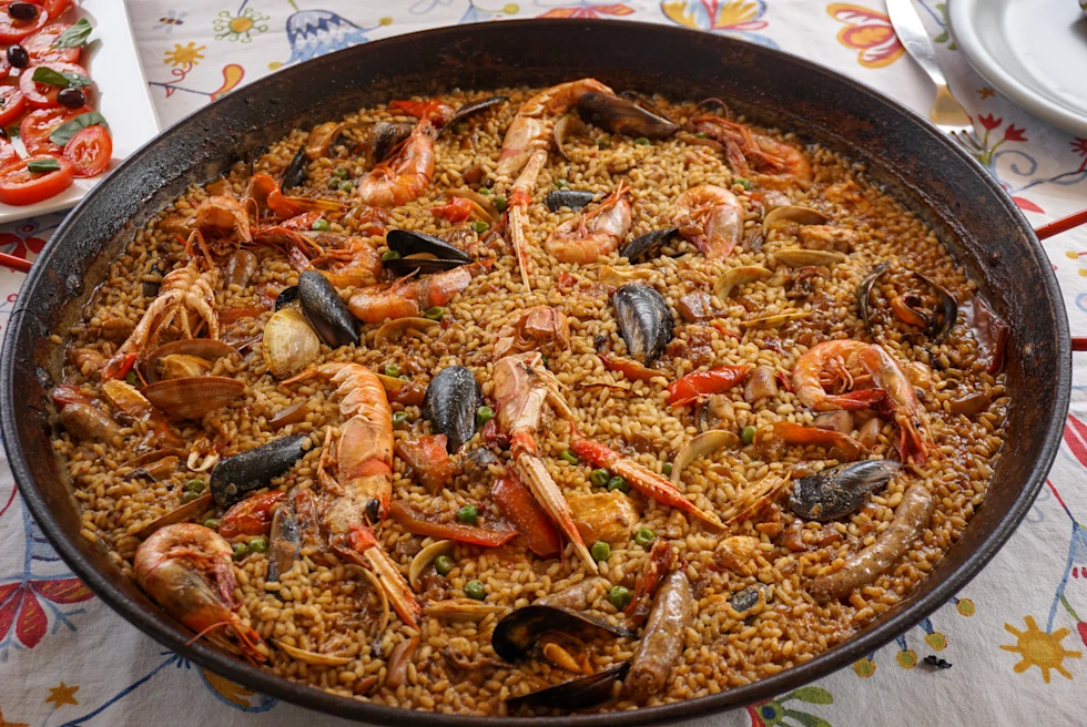 A paella bowl with rice and seafood.